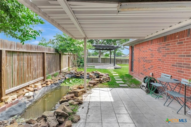 108 Bridle Ln, Victoria, TX 77904 - fenced backyard with a patio and a garden pond