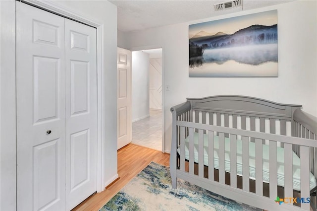 108 Bridle Ln, Victoria, TX 77904 - bedroom featuring wood finished floors, a closet, and a nursery area