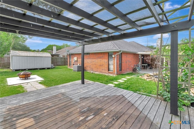 108 Bridle Ln, Victoria, TX 77904 - wooden deck with a fire pit, central AC unit, and a pergola