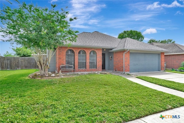 108 Bridle Ln, Victoria, TX 77904 - view of front of house featuring an attached garage, driveway, brick siding, and roof with shingles