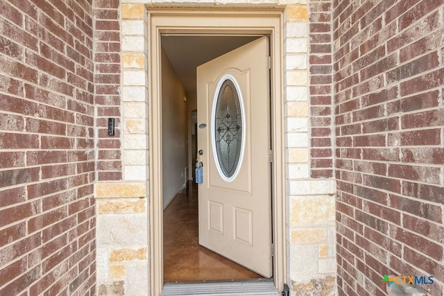 view of exterior entry featuring brick siding