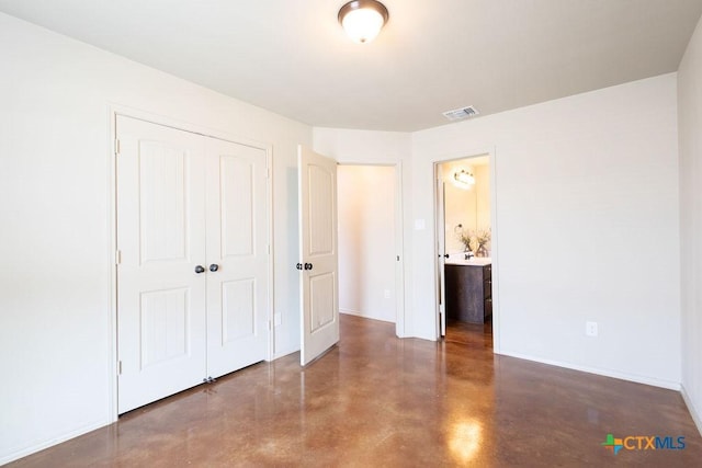 unfurnished bedroom featuring concrete flooring, a closet, visible vents, and baseboards