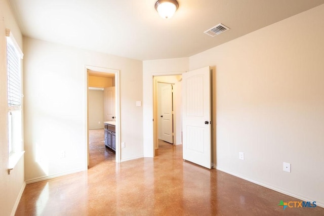 unfurnished bedroom featuring concrete flooring, visible vents, and baseboards