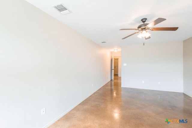 spare room featuring ceiling fan, visible vents, and concrete flooring