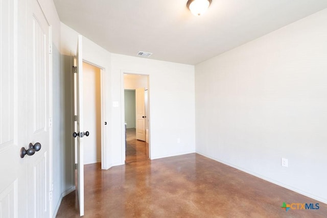 unfurnished room featuring concrete flooring, visible vents, and baseboards