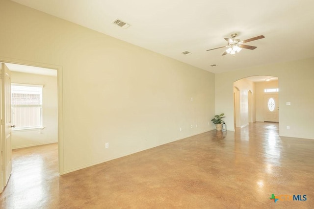 unfurnished room with arched walkways, ceiling fan, visible vents, and finished concrete floors