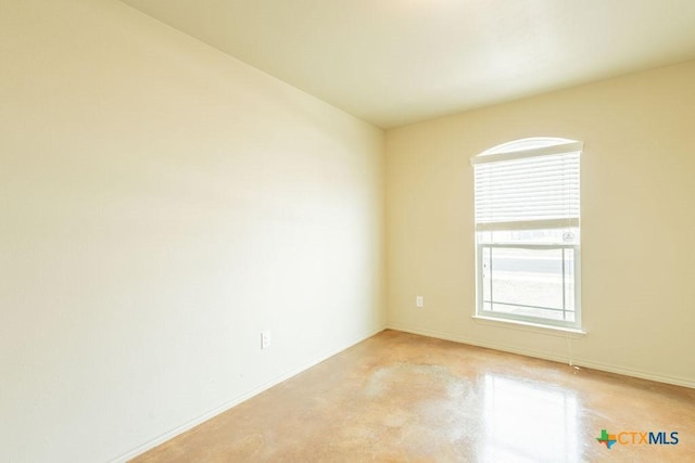 unfurnished room with concrete flooring