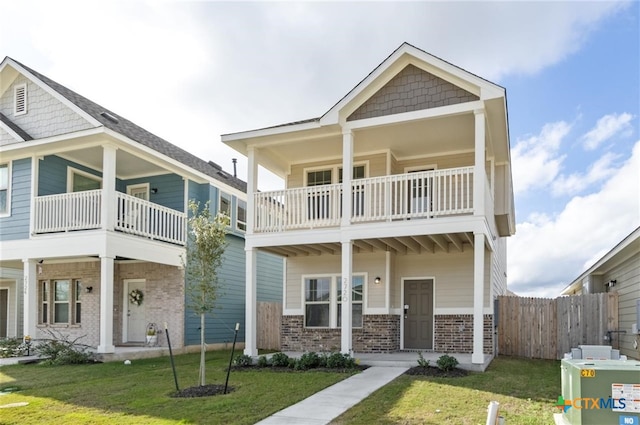 view of front of home featuring a balcony and a front lawn