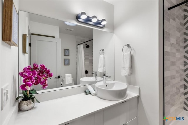 bathroom featuring a shower with shower curtain and vanity