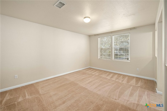 carpeted spare room with a textured ceiling