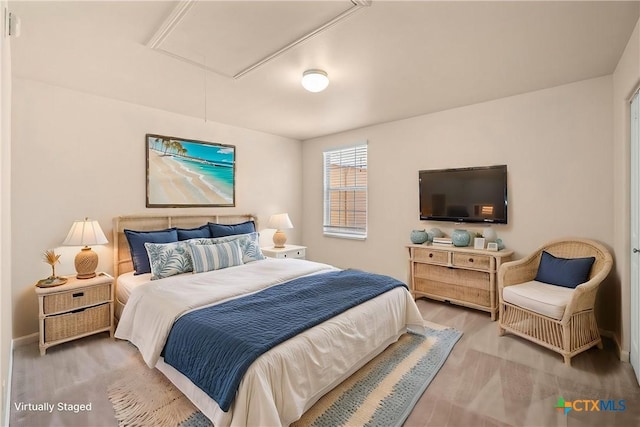 bedroom with attic access and wood finished floors