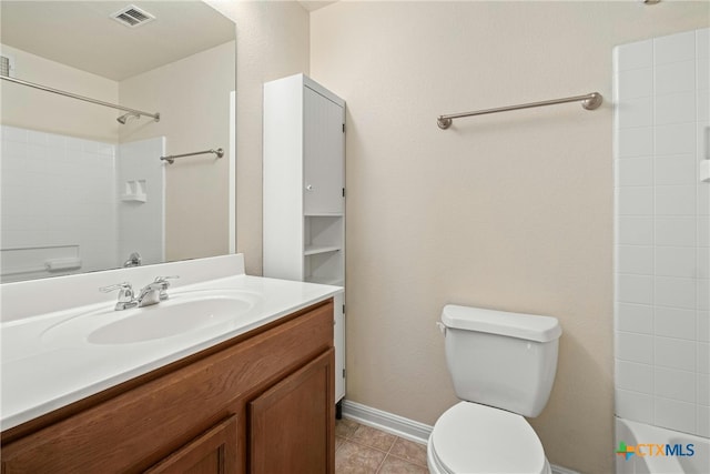 bathroom with toilet, vanity, and tile patterned flooring