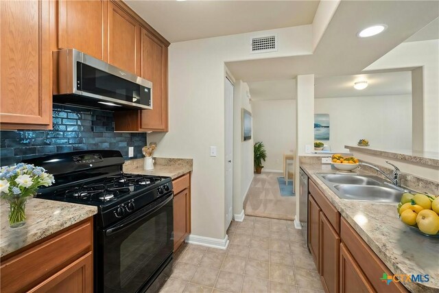 kitchen with a textured ceiling, stainless steel dishwasher, and sink