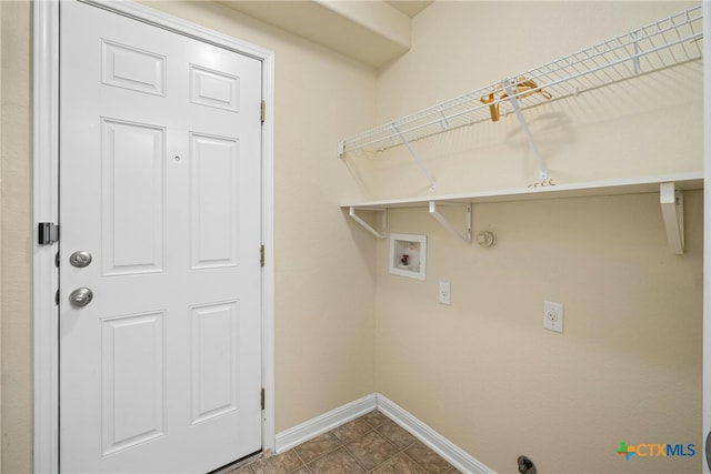 washroom with washer hookup, hookup for a gas dryer, laundry area, dark tile patterned floors, and baseboards