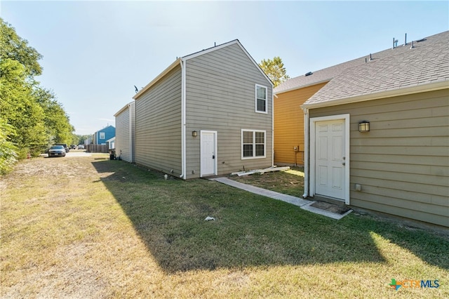 rear view of property with a yard