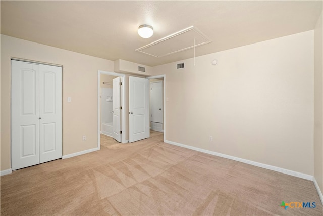 unfurnished bedroom with attic access, visible vents, light carpet, and baseboards