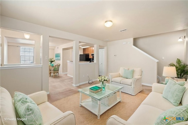 living area with baseboards and visible vents