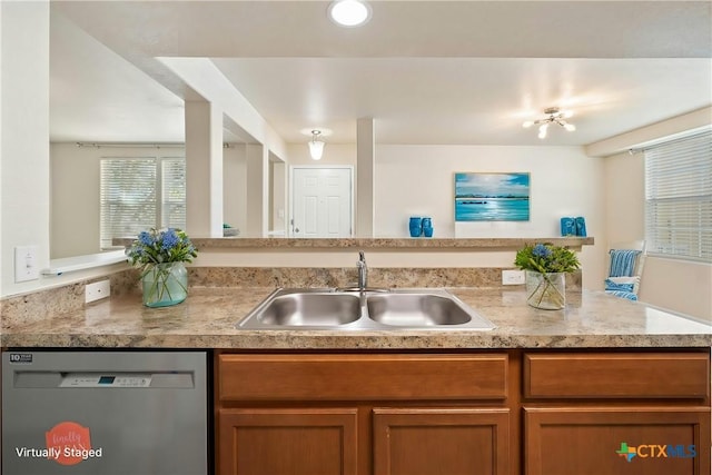 kitchen featuring dishwasher, light countertops, brown cabinetry, and a sink