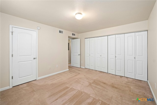 unfurnished bedroom featuring carpet floors, baseboards, and visible vents