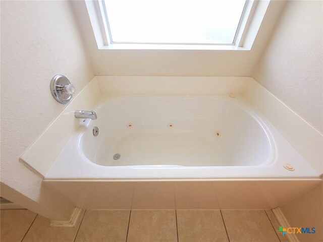 2810 Scottsdale Dr, Killeen, TX 76543 - bathroom with healthy amount of natural light, a whirlpool tub, tile patterned floors, a skylight, and a textured wall