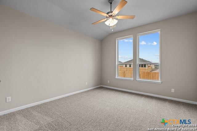 spare room with ceiling fan, lofted ceiling, and carpet floors