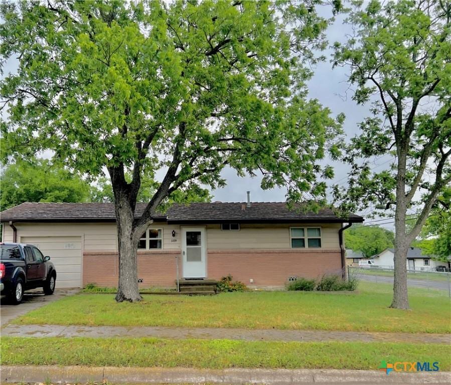 single story home with a garage and a front lawn