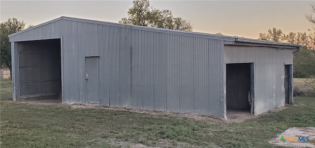 outdoor structure at dusk with a yard and a garage