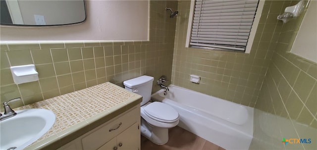 full bathroom featuring toilet, vanity, tile walls, and tiled shower / bath