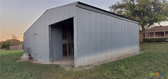 outdoor structure at dusk featuring a yard