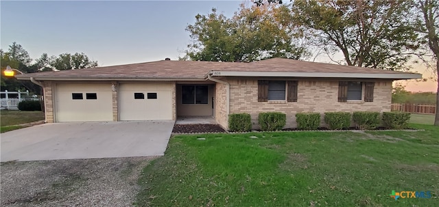 single story home with a lawn and a garage