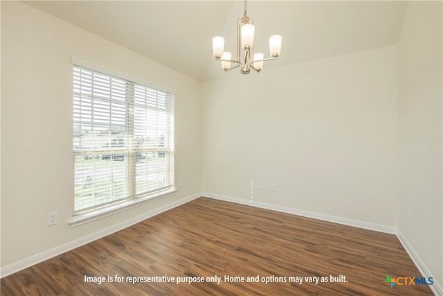 empty room featuring dark hardwood / wood-style flooring and a chandelier