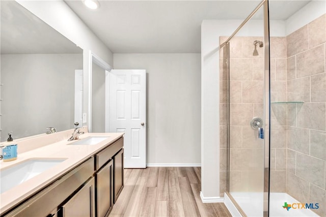 2358 Aylesbury Dr, Copperas Cove, TX 76522 - bathroom featuring wood finished floors, a stall shower, double vanity, and recessed lighting
