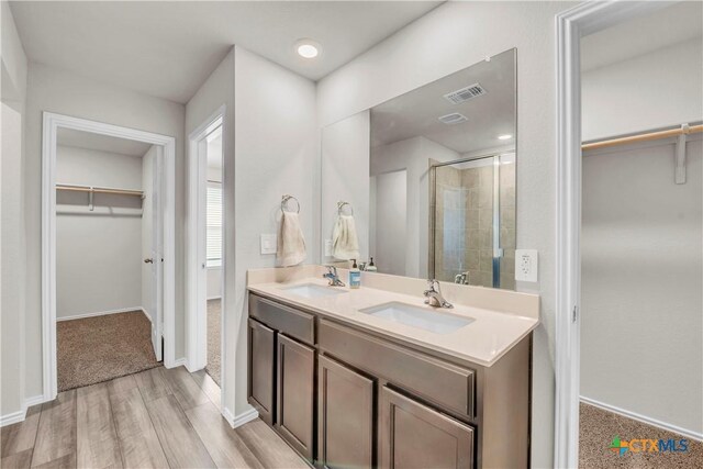 2358 Aylesbury Dr, Copperas Cove, TX 76522 - bathroom with a walk in closet, double vanity, a stall shower, and wood finished floors
