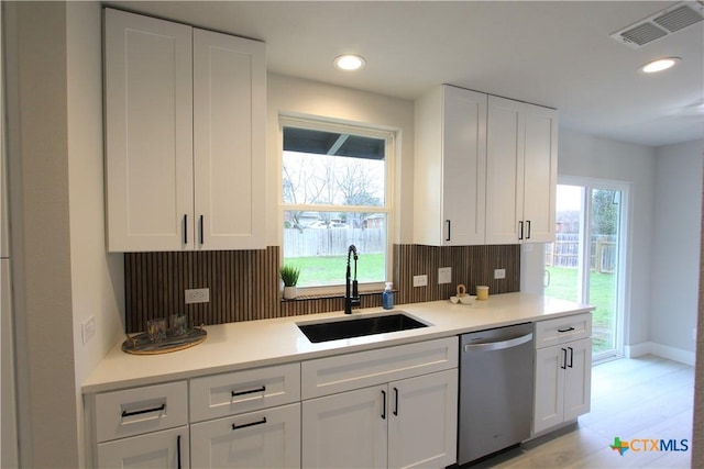 kitchen with visible vents, white cabinets, dishwasher, light countertops, and a sink