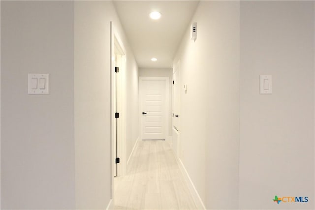 corridor with recessed lighting, light wood-style flooring, and baseboards