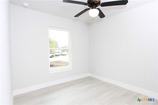 unfurnished room with a ceiling fan, light wood-style flooring, and baseboards