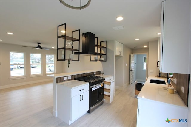 kitchen featuring light countertops, white cabinetry, and gas stove