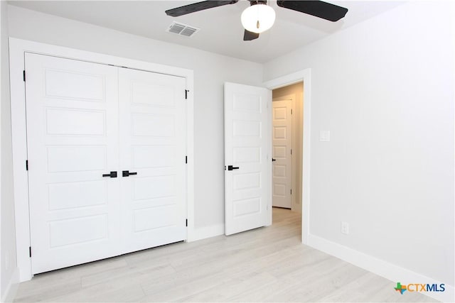 unfurnished bedroom featuring light wood-type flooring, baseboards, visible vents, and a closet