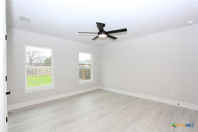 unfurnished room with light wood finished floors, baseboards, visible vents, and a ceiling fan