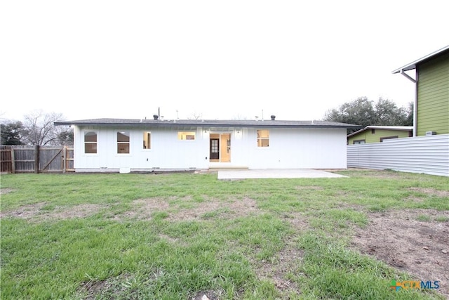 rear view of house featuring a yard, a fenced backyard, and a patio