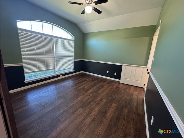 empty room with ceiling fan, dark hardwood / wood-style flooring, and vaulted ceiling