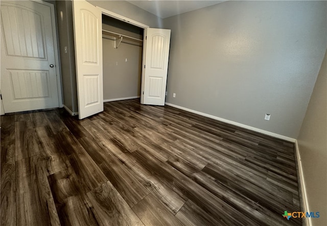 unfurnished bedroom featuring dark hardwood / wood-style flooring and a closet