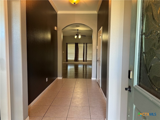 corridor featuring light tile patterned floors and ornamental molding