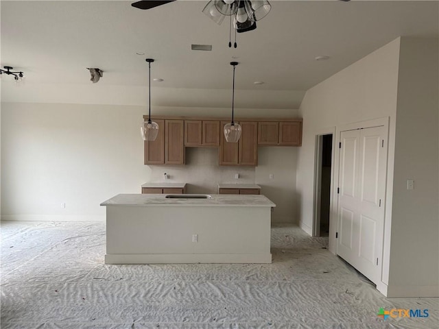 kitchen with visible vents, ceiling fan, a kitchen island, brown cabinets, and pendant lighting