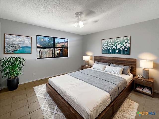 tiled bedroom with a textured ceiling and ceiling fan