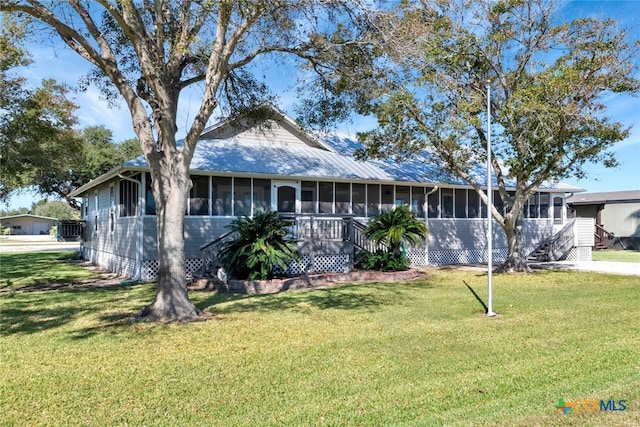 view of front facade featuring a sunroom and a front lawn