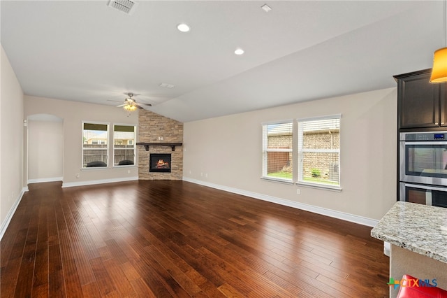 unfurnished living room featuring a stone fireplace, baseboards, visible vents, a ceiling fan, and lofted ceiling