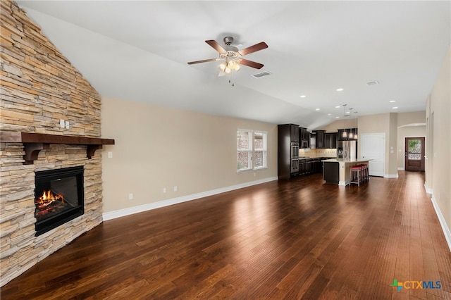 unfurnished living room with dark wood-style floors, visible vents, ceiling fan, and vaulted ceiling