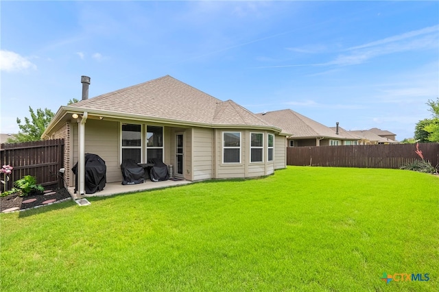 back of property featuring a lawn, a fenced backyard, and a patio area