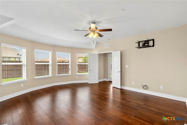 unfurnished room with baseboards, visible vents, a ceiling fan, and dark wood-type flooring
